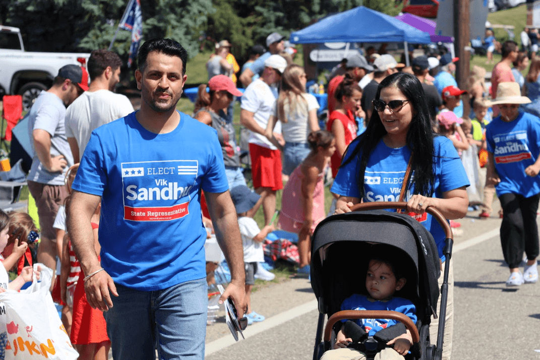Vik, Preet & Teja Sandhu walking in a parade